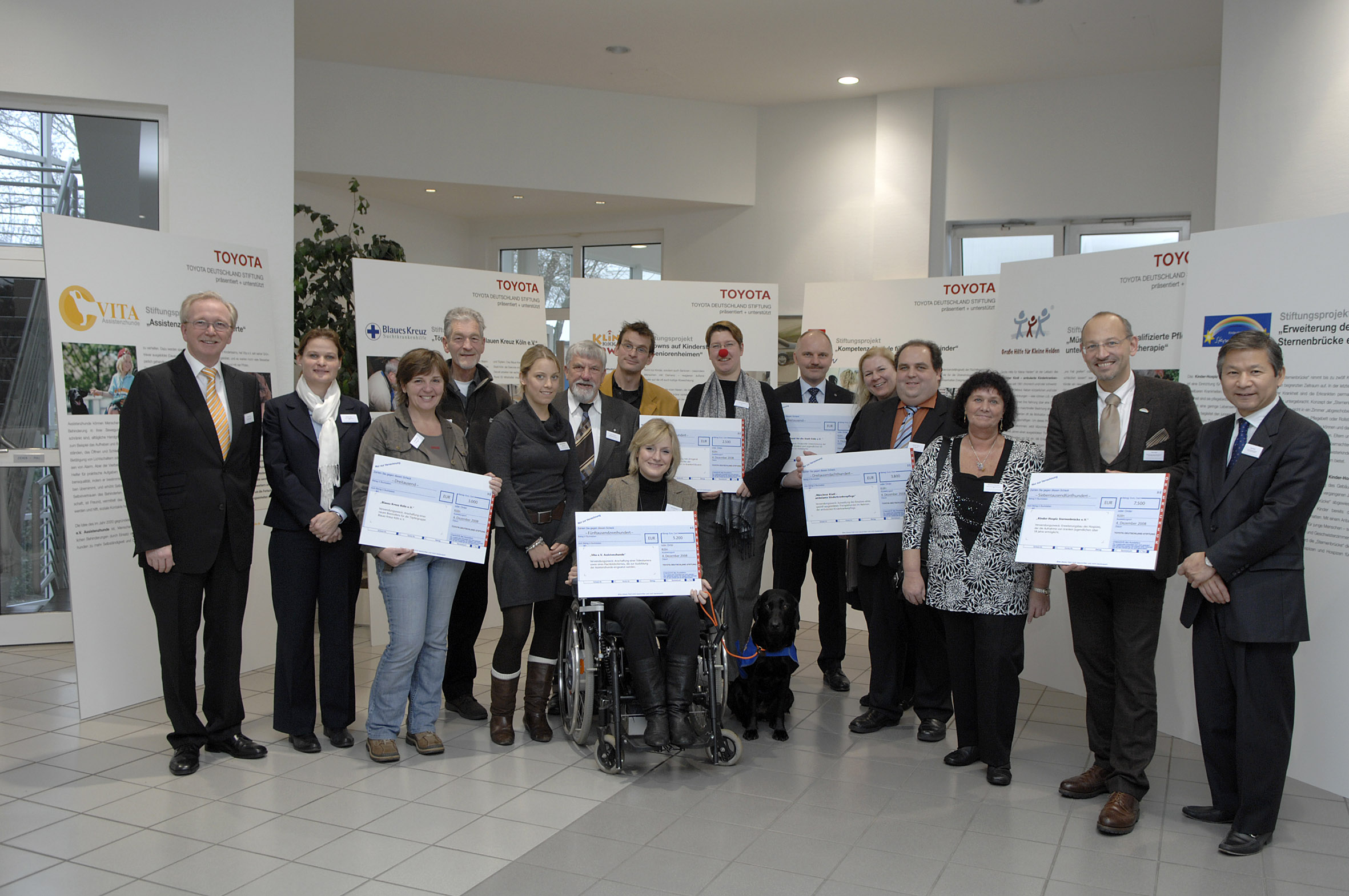 Stiftungsfeier "Toyota Deutschland Stiftung": Lothar Feuser, Stiftungs-Vorstandsvorsitzender(li.), die Vertreter der sechs geförderten Organisationen sowie die Paten aus den Reihen der Mitarbeiter von Toyota Deutschland und Keiji Sudo, Kuratoriumsvorsitze
